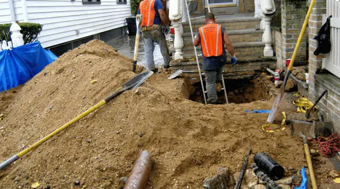 Contractors performing foundation protection and exterior drainage excavation near residential home steps in Chandler, AZ